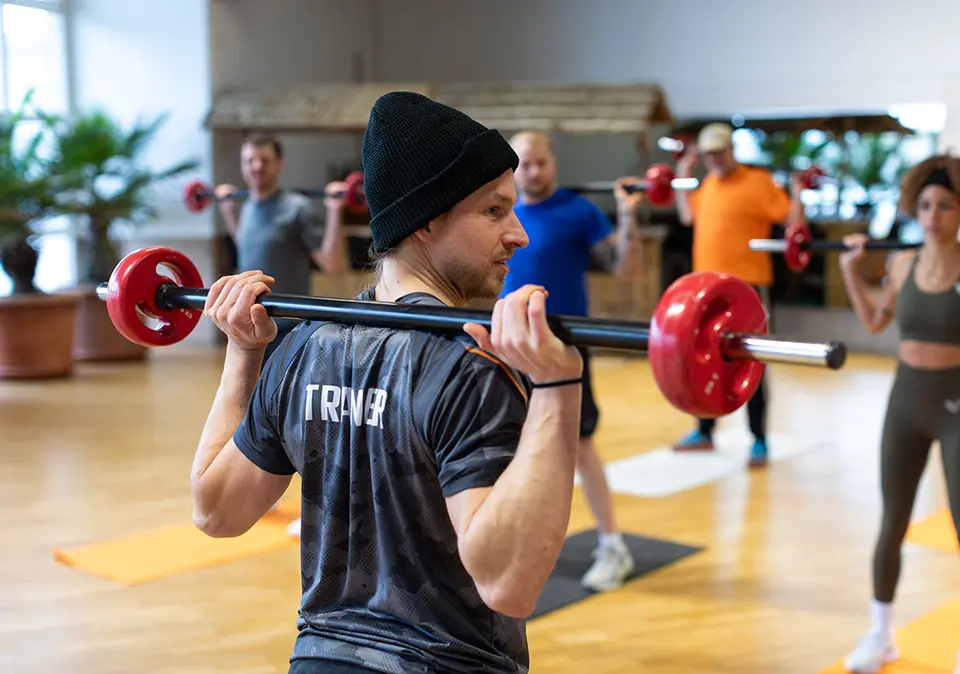 Teilnehmer beim Reha-Sport mit Hantelstange in der SportsFactory